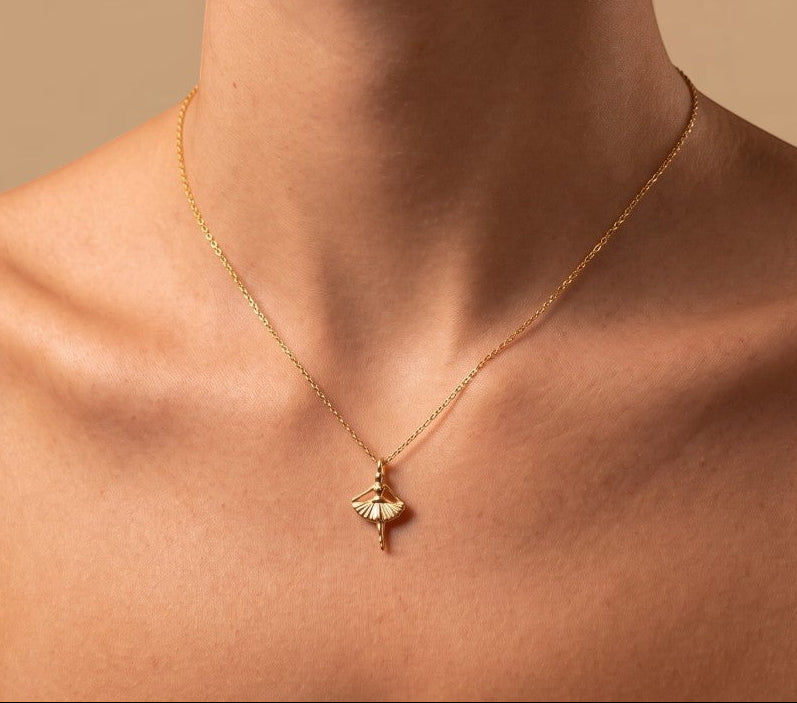 RITI delicate gold ballerina necklace with a fan-shaped skirt and intricate engravings. Minimalist pendant.