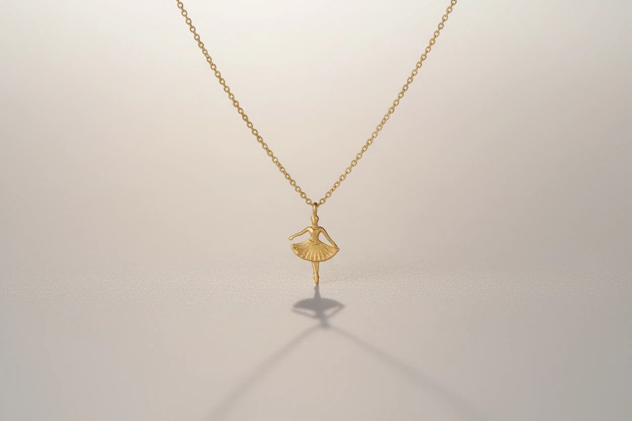 RITI delicate gold ballerina necklace with a fan-shaped skirt and intricate engravings. Minimalist pendant.