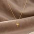 RITI delicate gold ballerina necklace with a fan-shaped skirt and intricate engravings. Minimalist pendant.
