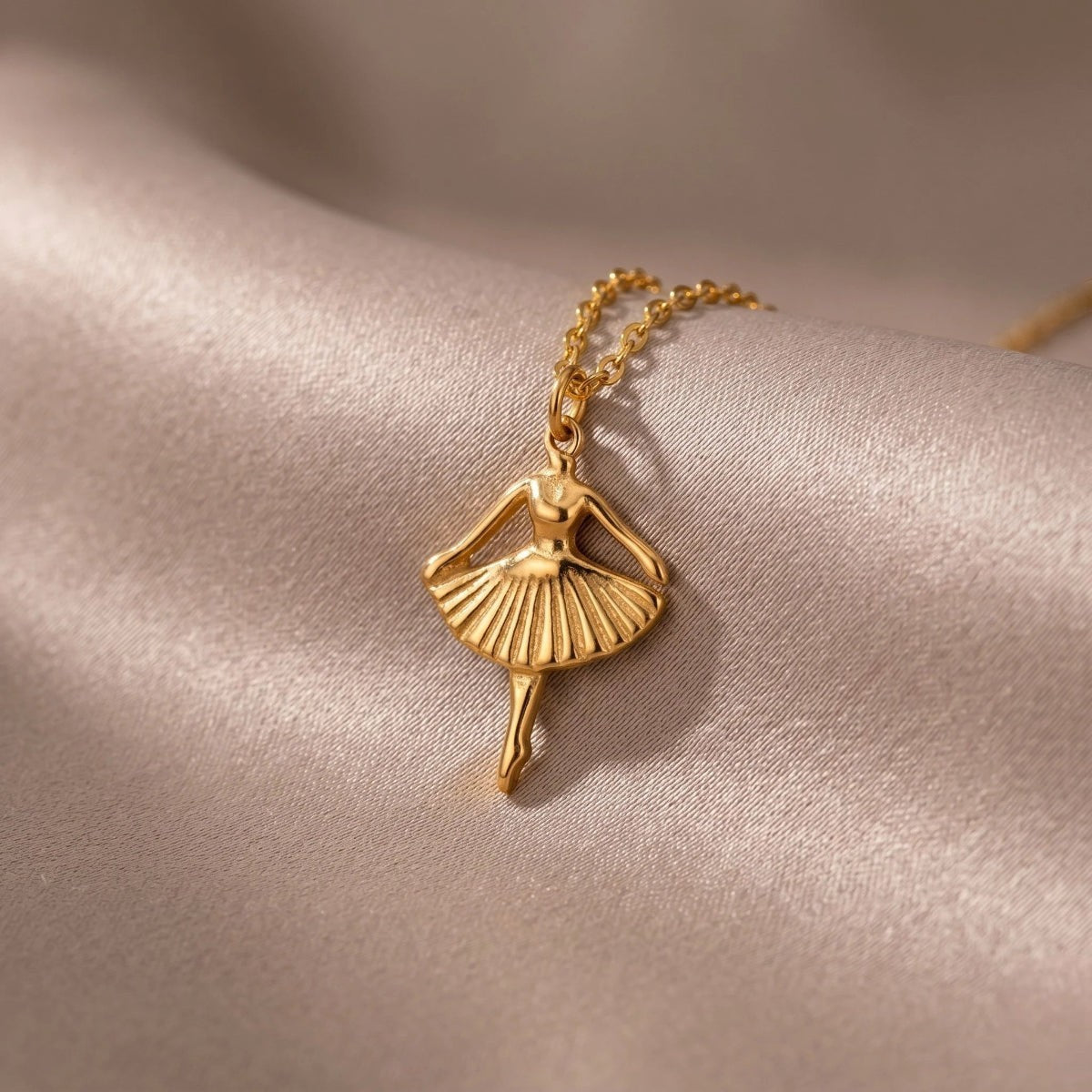 RITI gold-tone ballerina pendant necklace with delicate fan-shaped skirt and fine chain. Minimalist jewelry.